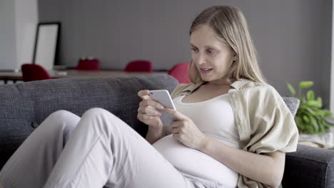 Glückliche-Schwangere-Frau,-Die-Auf-Dem-Smartphone-Tippt